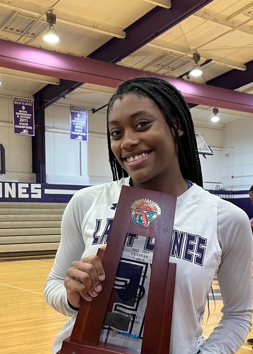 Photo of Jocelyn Wallace on basketball court holding award.